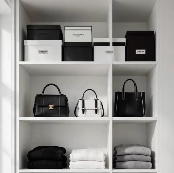 Offenes Regal mit Aufbewahrungsboxen, Handtaschen und gefalteten Pullovern